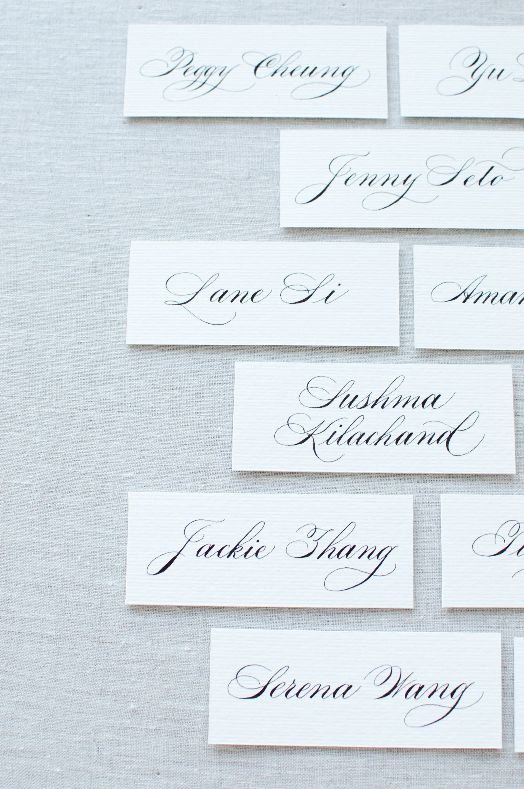 Handwritten calligraphy place cards arranged for a luxury brand event