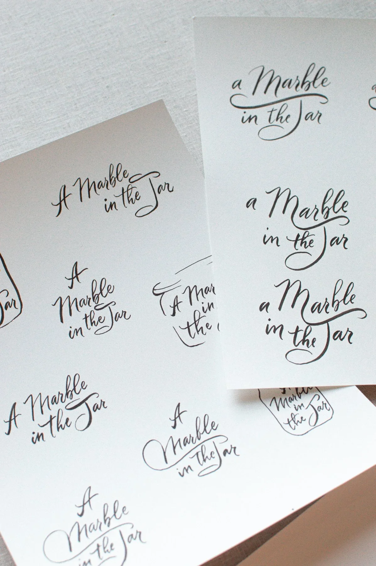 Hand-painted watercolor title lettering explorations for A Marble in the Jar