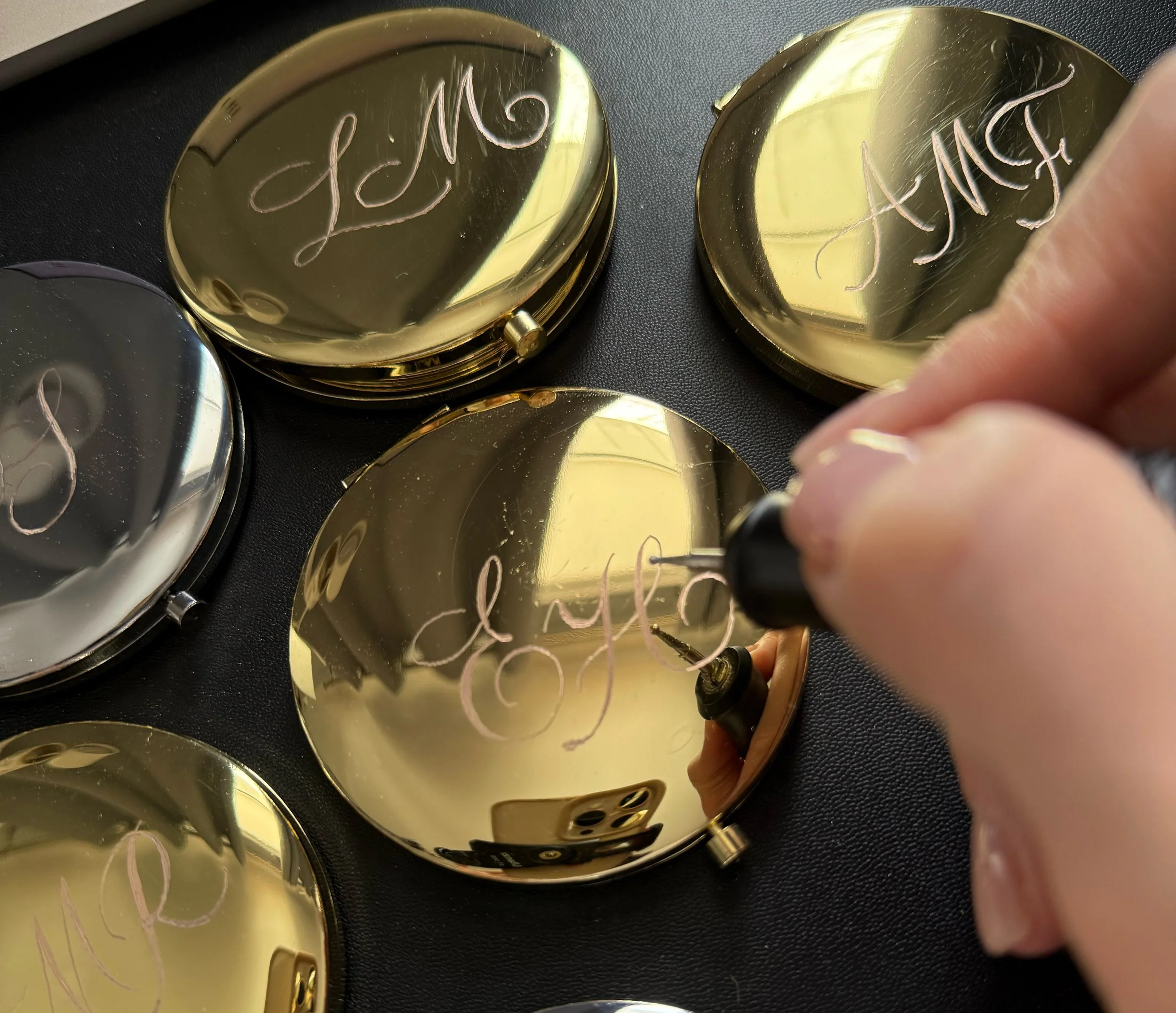Hand engraving initials on gold compact mirrors for luxury gift personalization