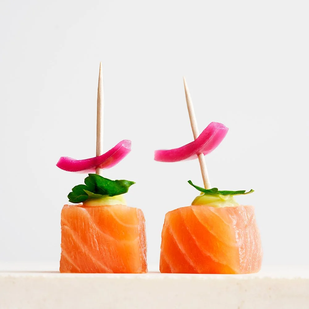 To appetizers med laks, syltede rødløg og grøn garniture