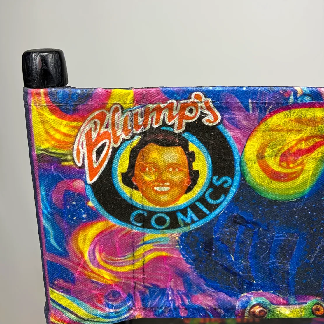 Close-up of a colorful decoupage-print canvas with the logo of Blump's Comics, featuring a smiling face with headphones, and surrounded by cosmic and psychedelic designs. Part of "TOAD" movie poster.