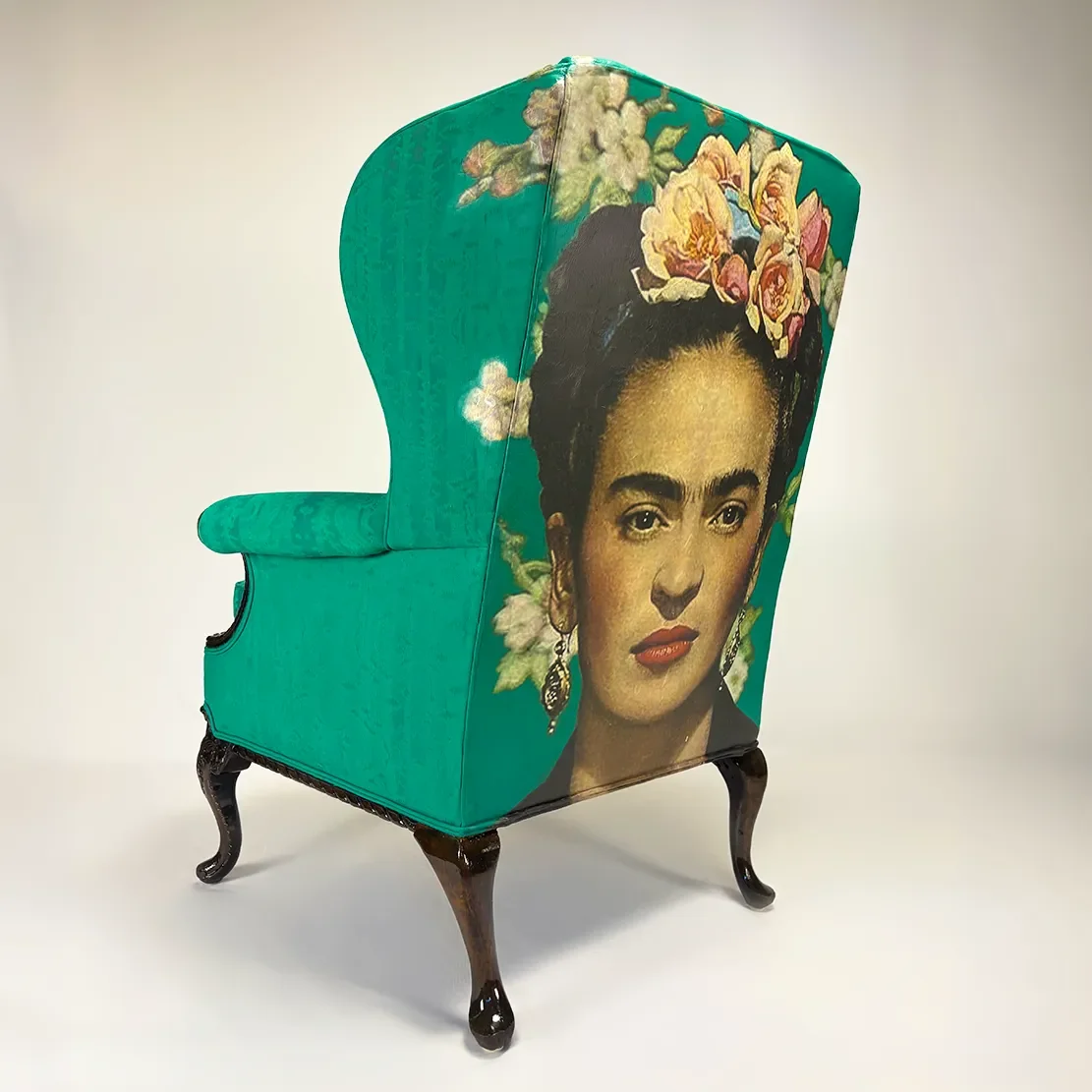 Furniture piece with a mural of a woman with floral accessories on a teal background.