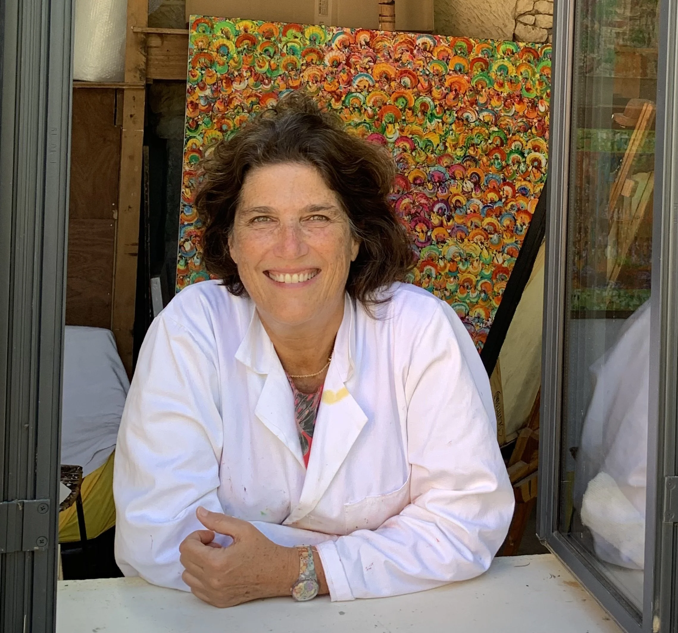 Portrait of contemporary artist Christine Drummond in her studio with colourful painting behind her