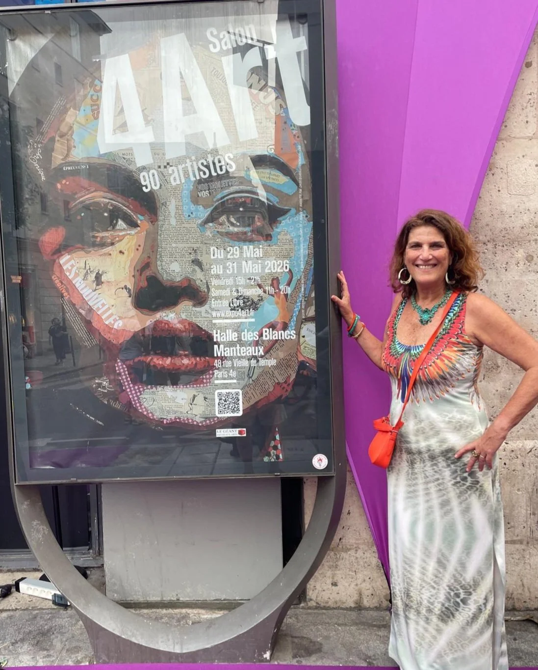 Franco-Brazilian artist Christine Drummond beside the Expo4Art Paris 2026 exhibition poster at Halle des Blancs-Manteaux in Paris.