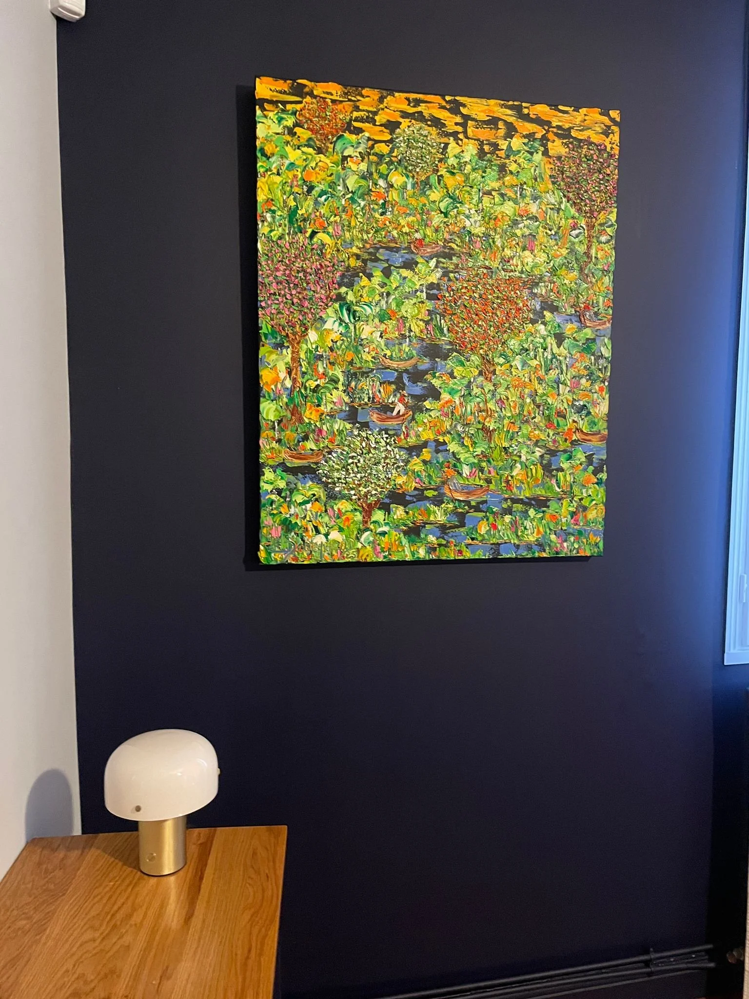 Contemporary botanical painting by Christine Drummond displayed in elegant modern French interior with dark blue accent wall and designer lighting