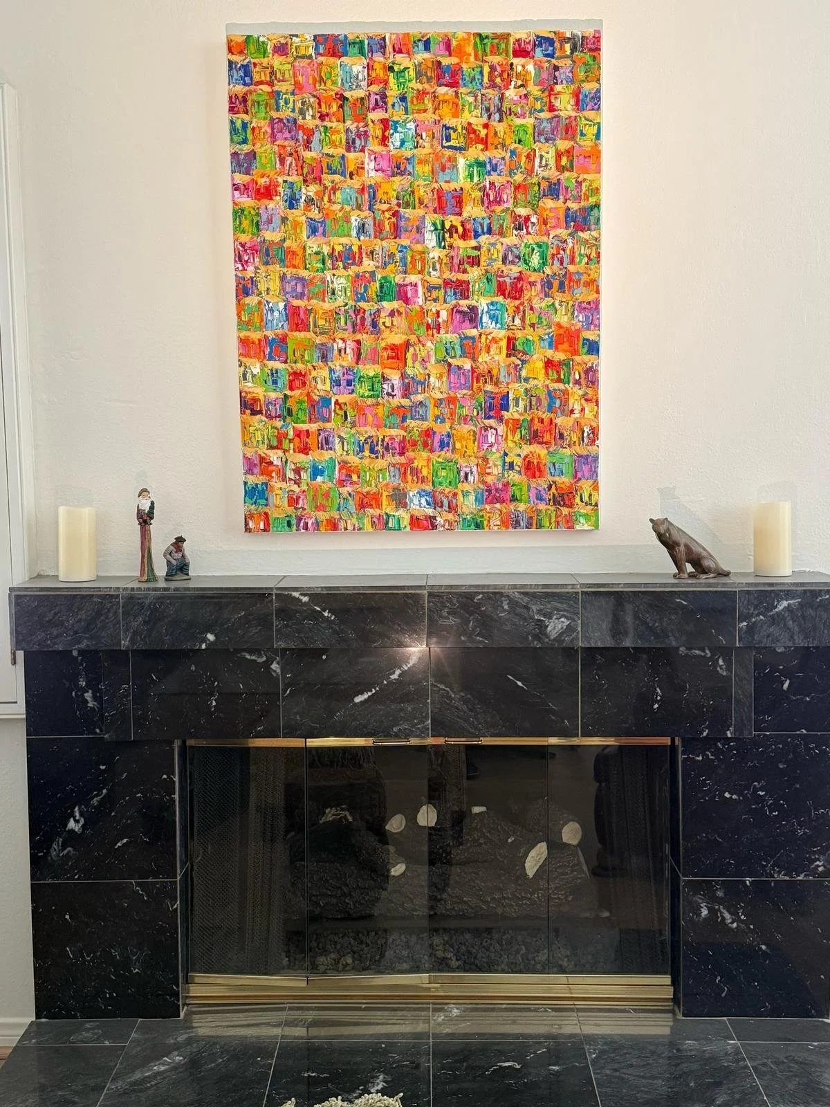 Colourful contemporary painting by Christine Drummond displayed above elegant dark marble fireplace in luxury Rancho Mirage, California home interior