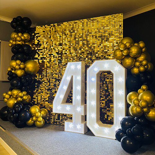 Gold shimmer wall with balloon decor and light up 40 for a party at Ely Football Club in Ely 