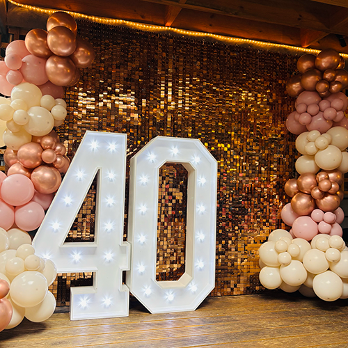 Rose gold shimmer wall with pink, rose gold and cream balloon decor and light up 40 at The Old Cannon Brewery in Bury St Edmunds