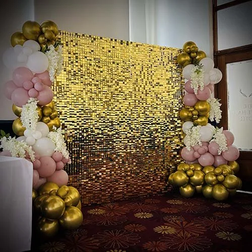 Gold shimmer wall with pink, white and gold balloon decor for an engagement party at The White Heart in Newmarket