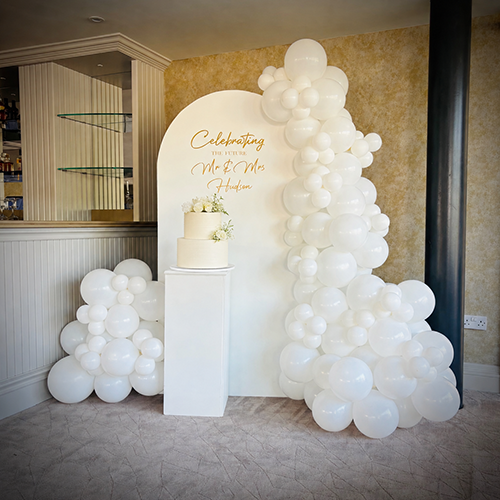Personalised background with balloon decor and cake stand at Cambridge Country Club in Cambridgeshire