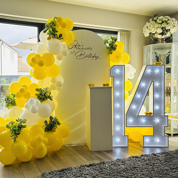 Lemon themed 14th Birthday display with personalsed board, yellow and white balloons, faux foliage and real lemons in Newmarket, Suffolk