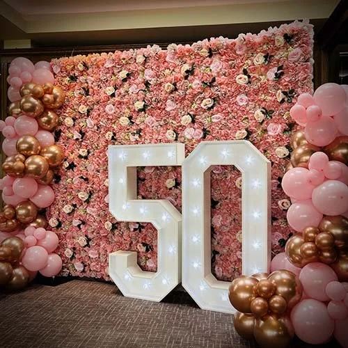Pink flower wall with balloon decor and light up 50 at Gog Magog Golf Club in Cambridge
