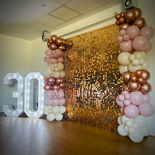 Rose gold shimmer wall with cream, rose gold and pink balloons and 4ft light up 30 numbers