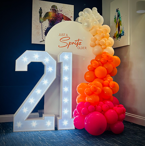 personalised background with sunset ombre balloons and 4ft light up 21 numbers 