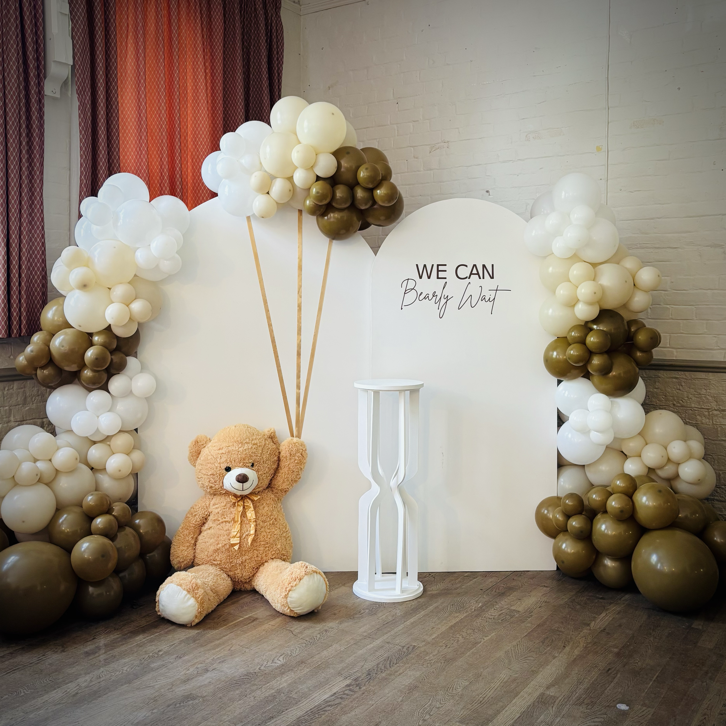 Baby Shower set up with double white background, balloon decoration, teddy bear and cake stand at Withersfield Village Hall. 