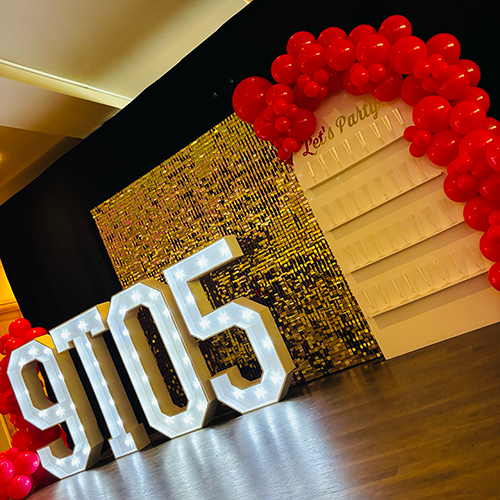 Gold shimmer wall with "9 TO 5" light up letters with prosecco wall and ballon decor for Landmark Theatres Press release of 9 to 5 at The New Theatre in Peterborough 