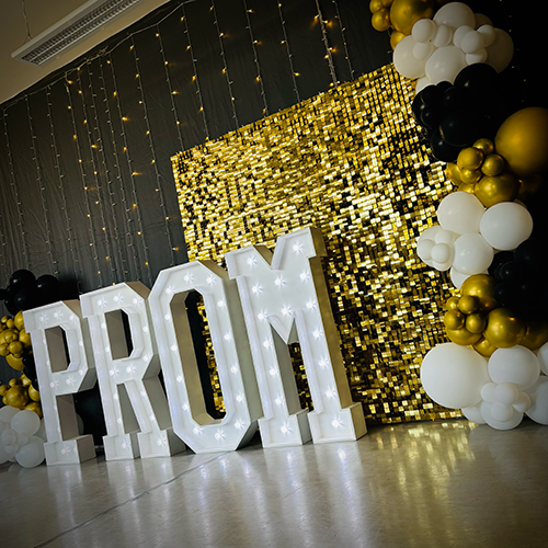 Gold shimmer wall with gold and white balloons and 4ft Light Up PROM letters