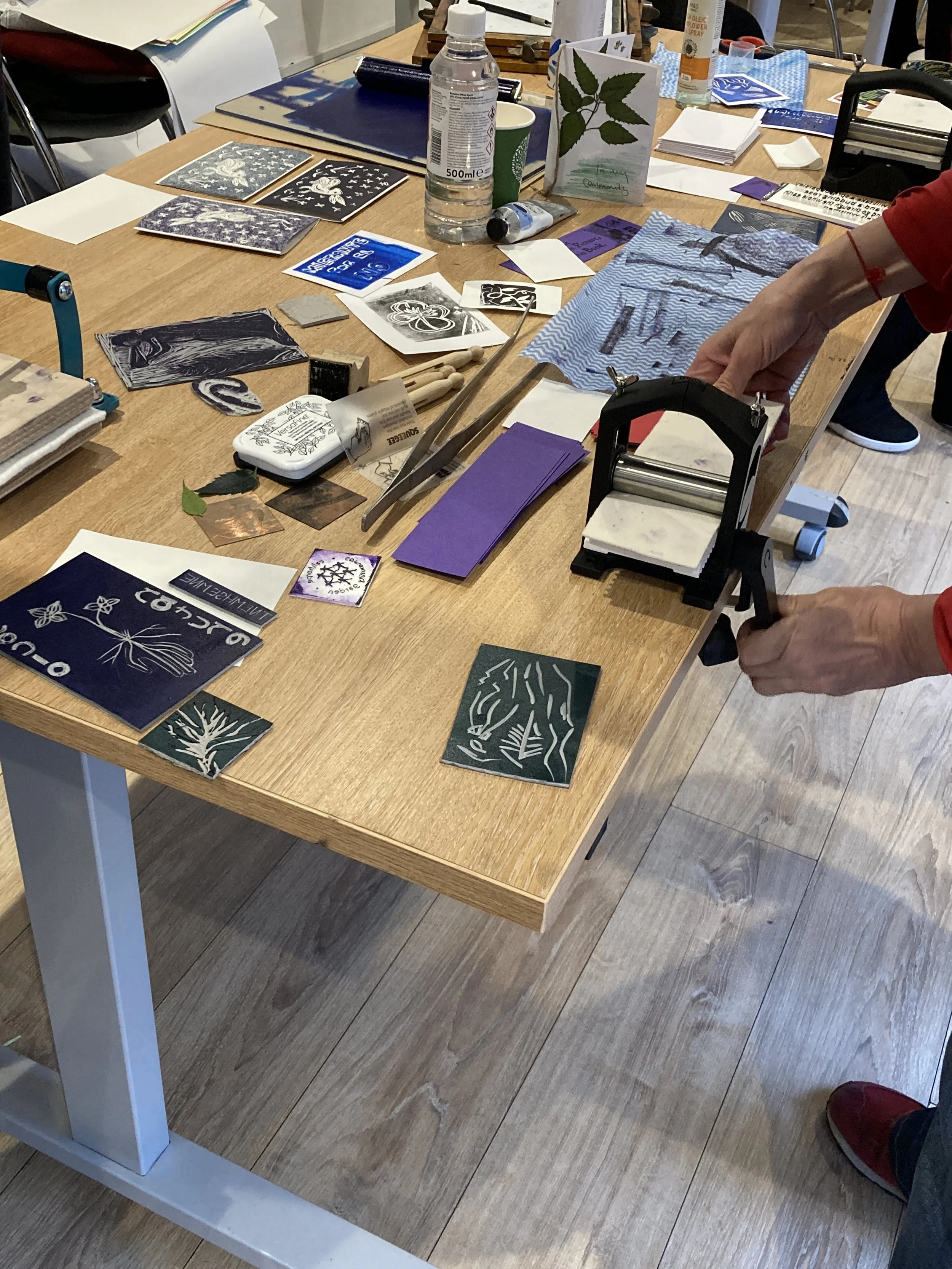 Print making materials and illustrations on a table.