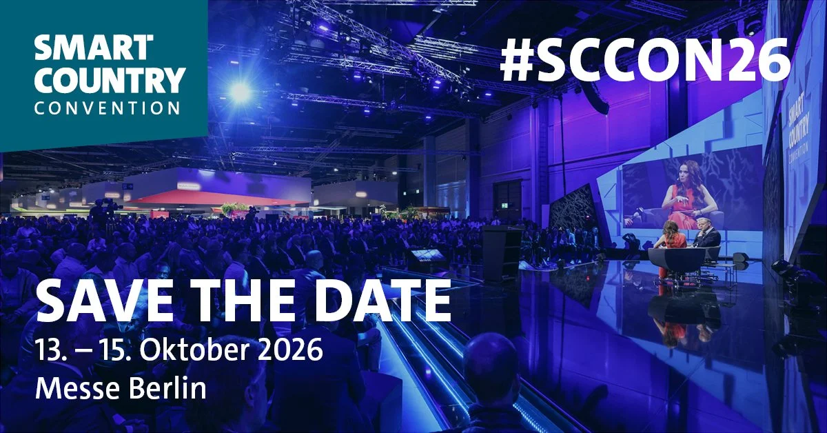 Ein Bild von einer großen Konferenzhalle mit einem Publikum, das auf eine Bühne schaut, auf der zwei Personen im Gespräch sitzen. Das Bild bewirbt die SMART COUNTRY CONVENTION vom 13. bis 15. Oktober 2026 in Berlin.