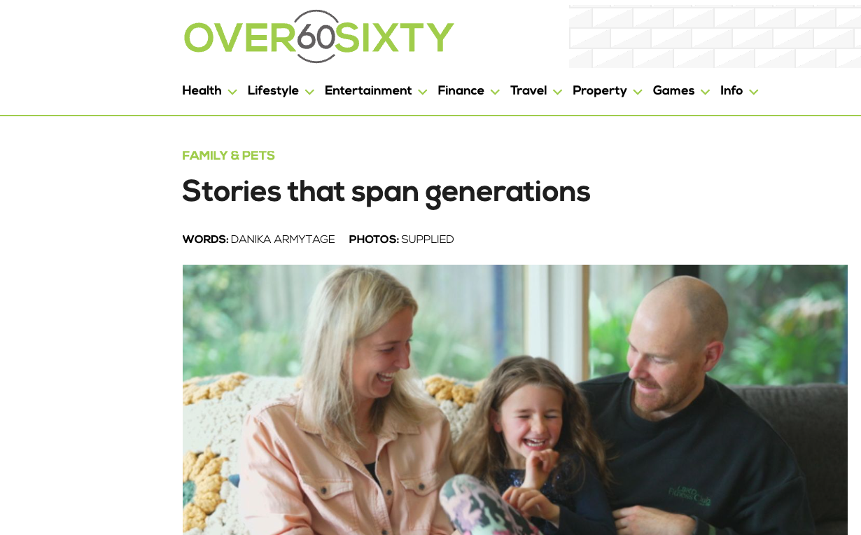 A family sitting on a couch, including a woman, a young girl, and a man, sharing a joyful moment together.