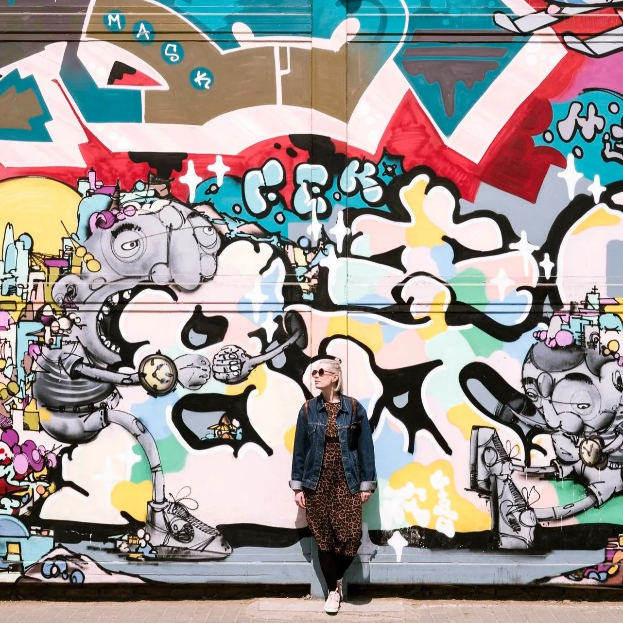 girl standing in front of a graffiti wall