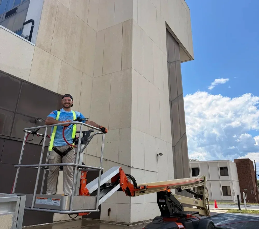 Commercial exterior cleaning technician working on a building exterior