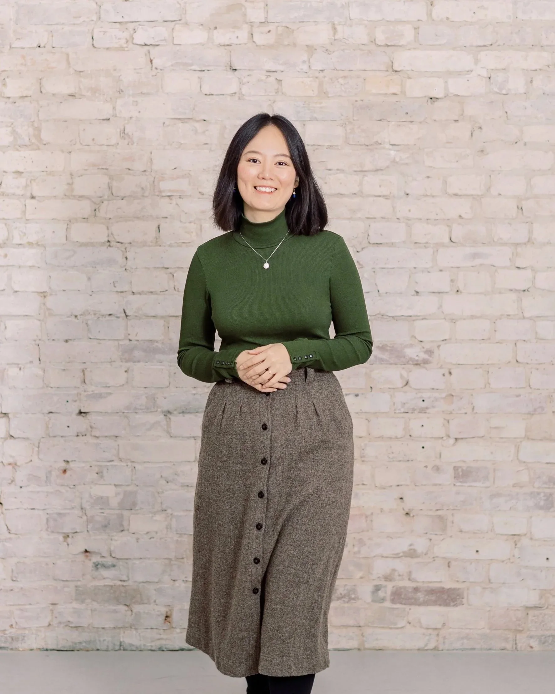 Duo Chen Photography, wedding photographer in Germany, smiling in front of brick wall