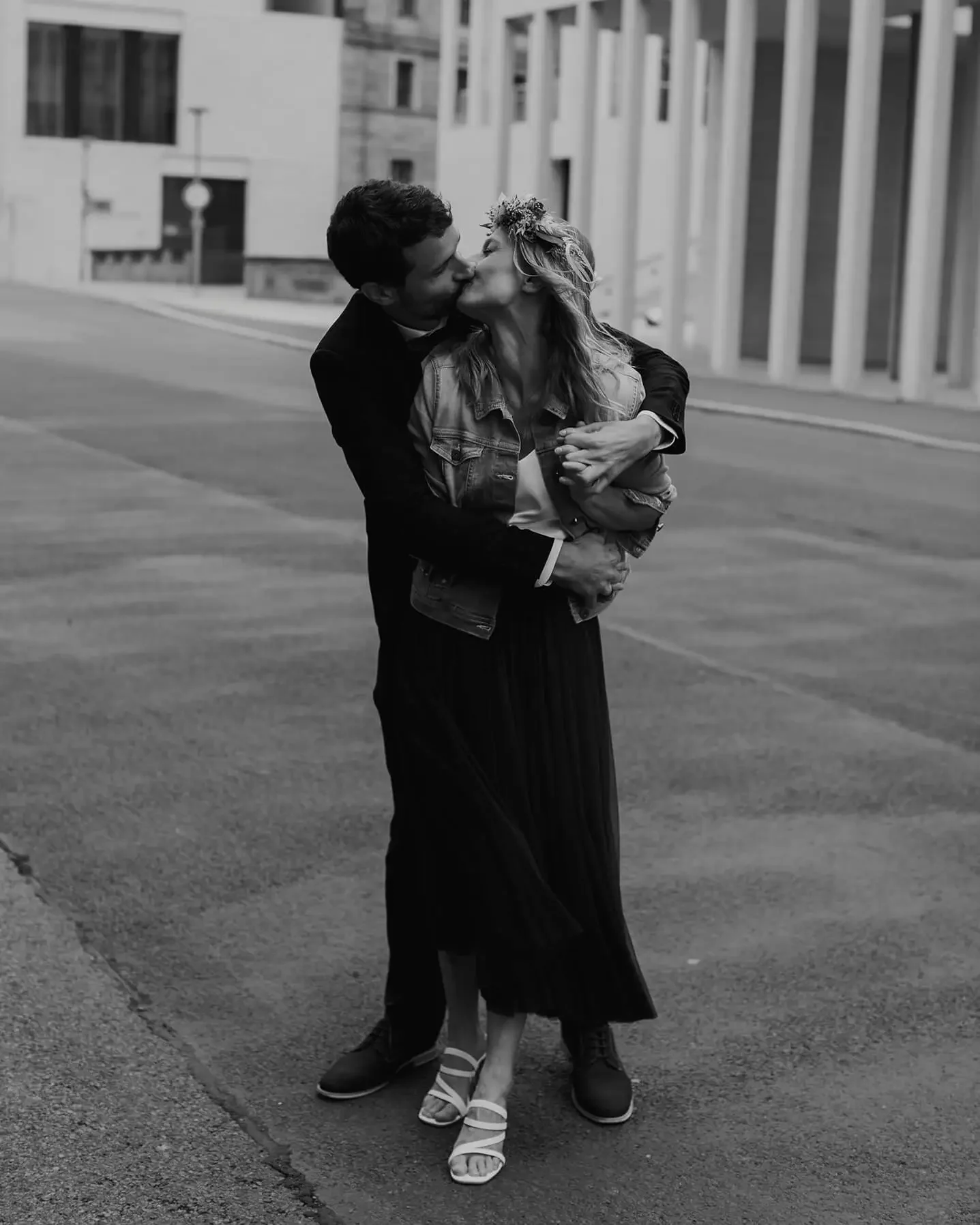 a bride and groom embracing and kissing in the streets of Berlin
