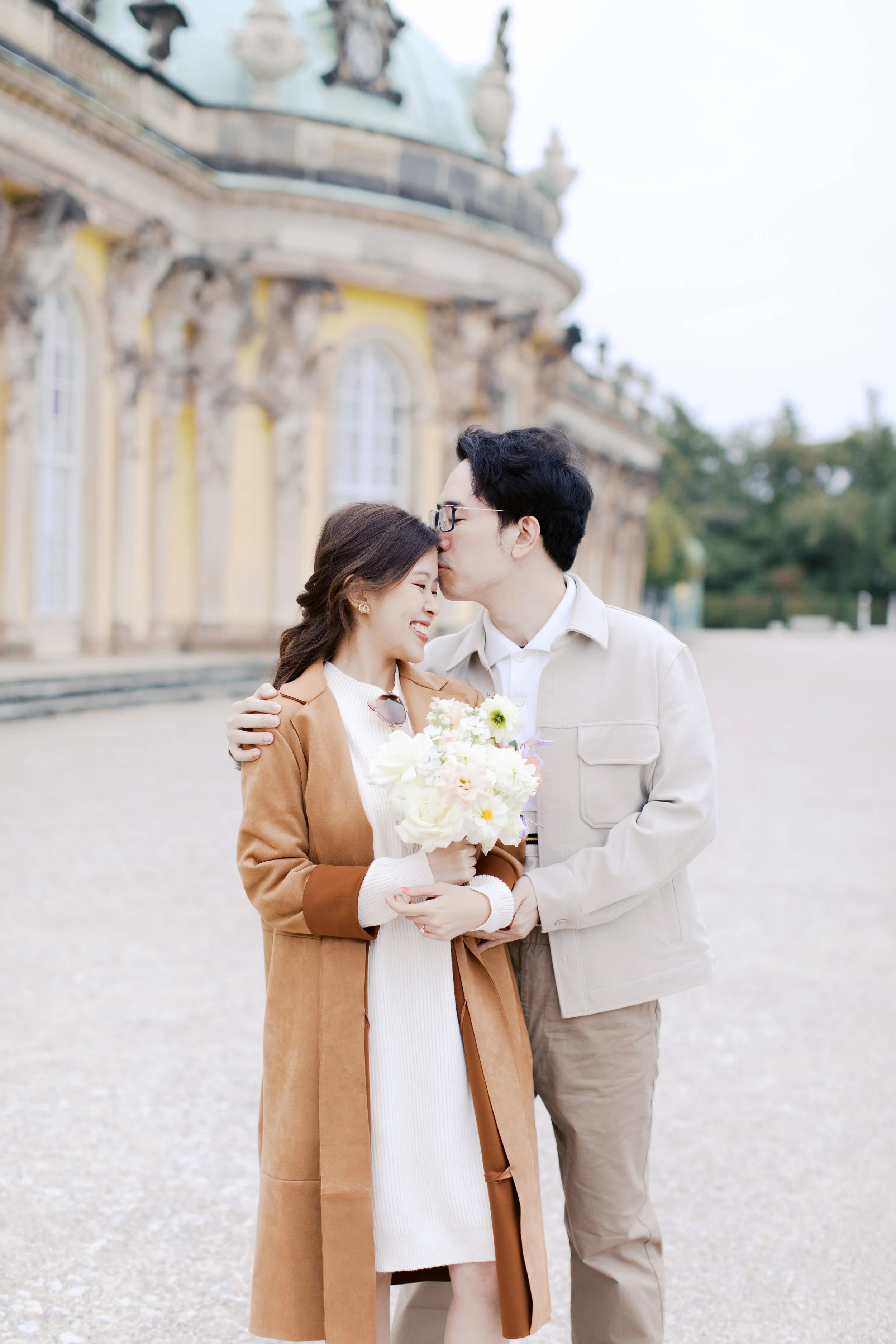 couple embracing after a proposal at schloss sanssouci park