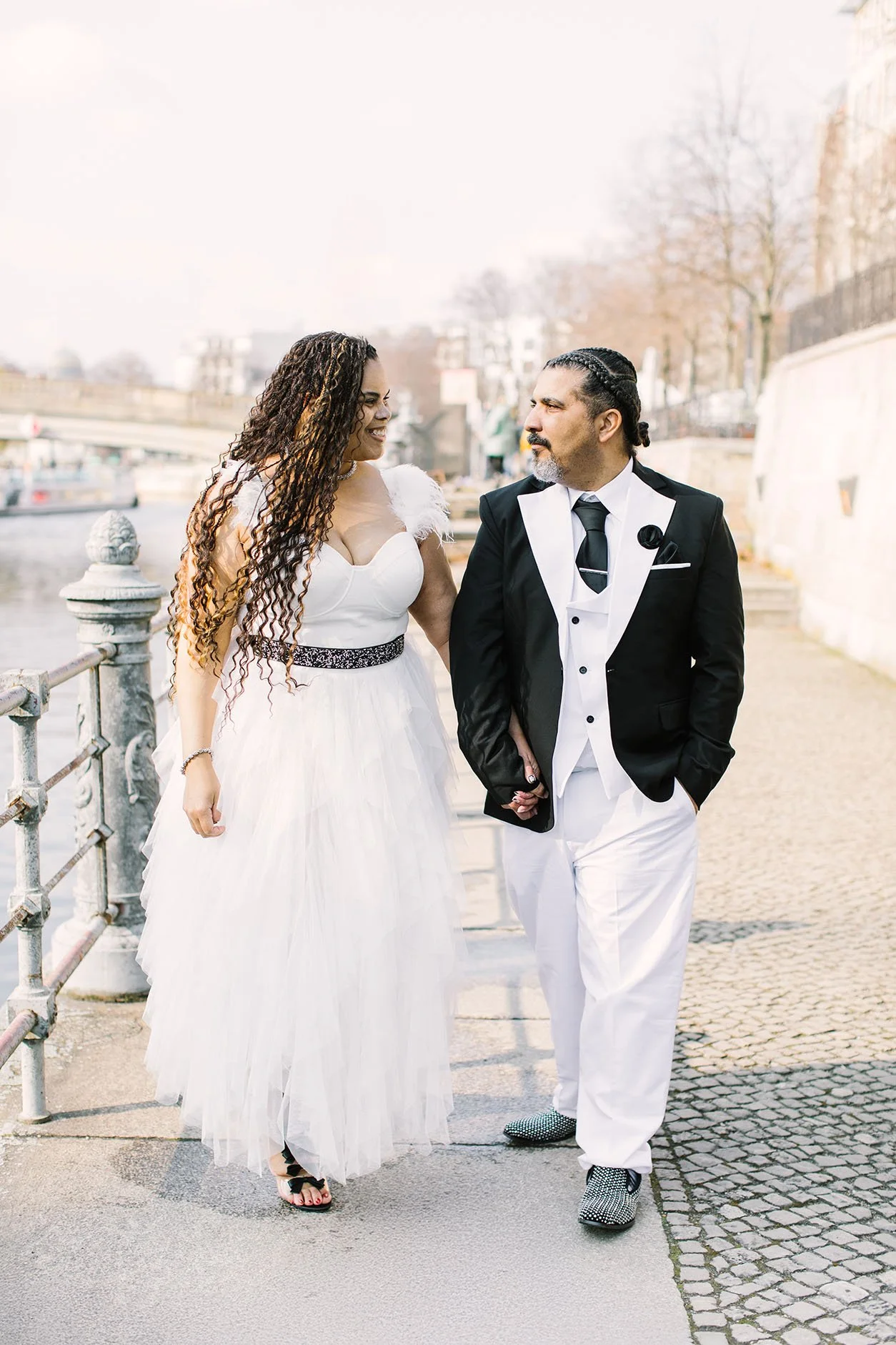 A wedding couple walking side by side holding hands in Berlin