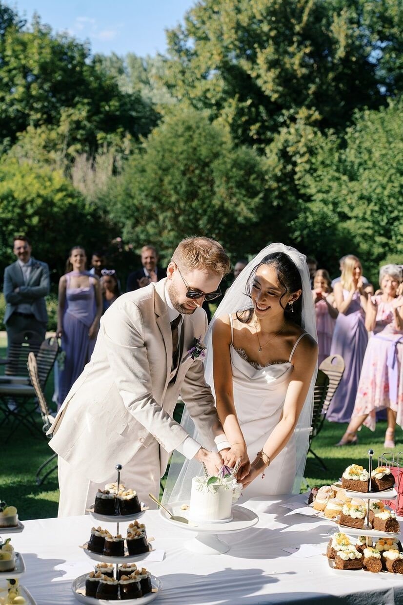Couple cutting a wedding cake at Gut Schloss Golm