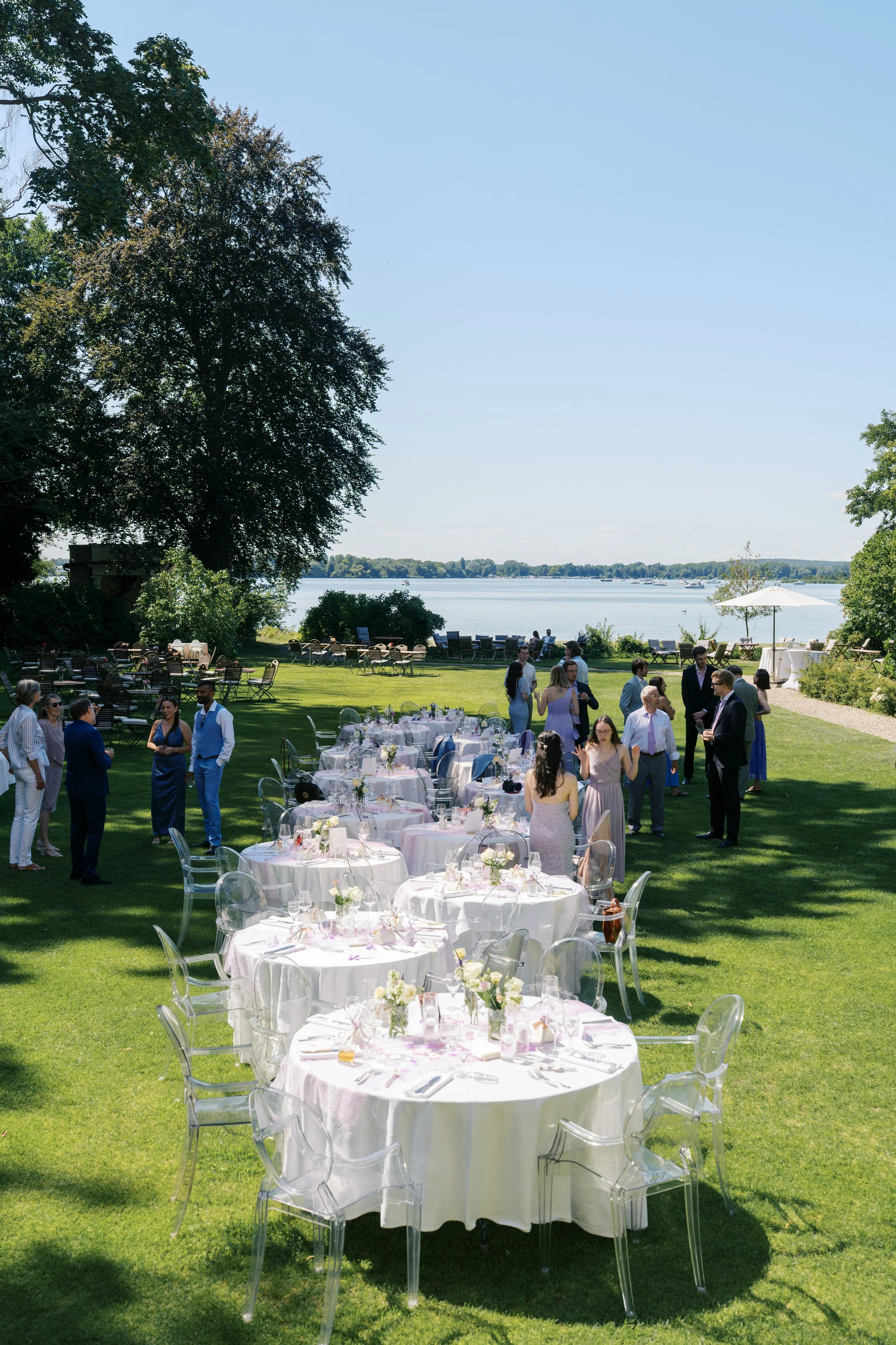 Tables set up by the lake at Gut Schloss Golm in Potsdam, Germany for a wedding reception