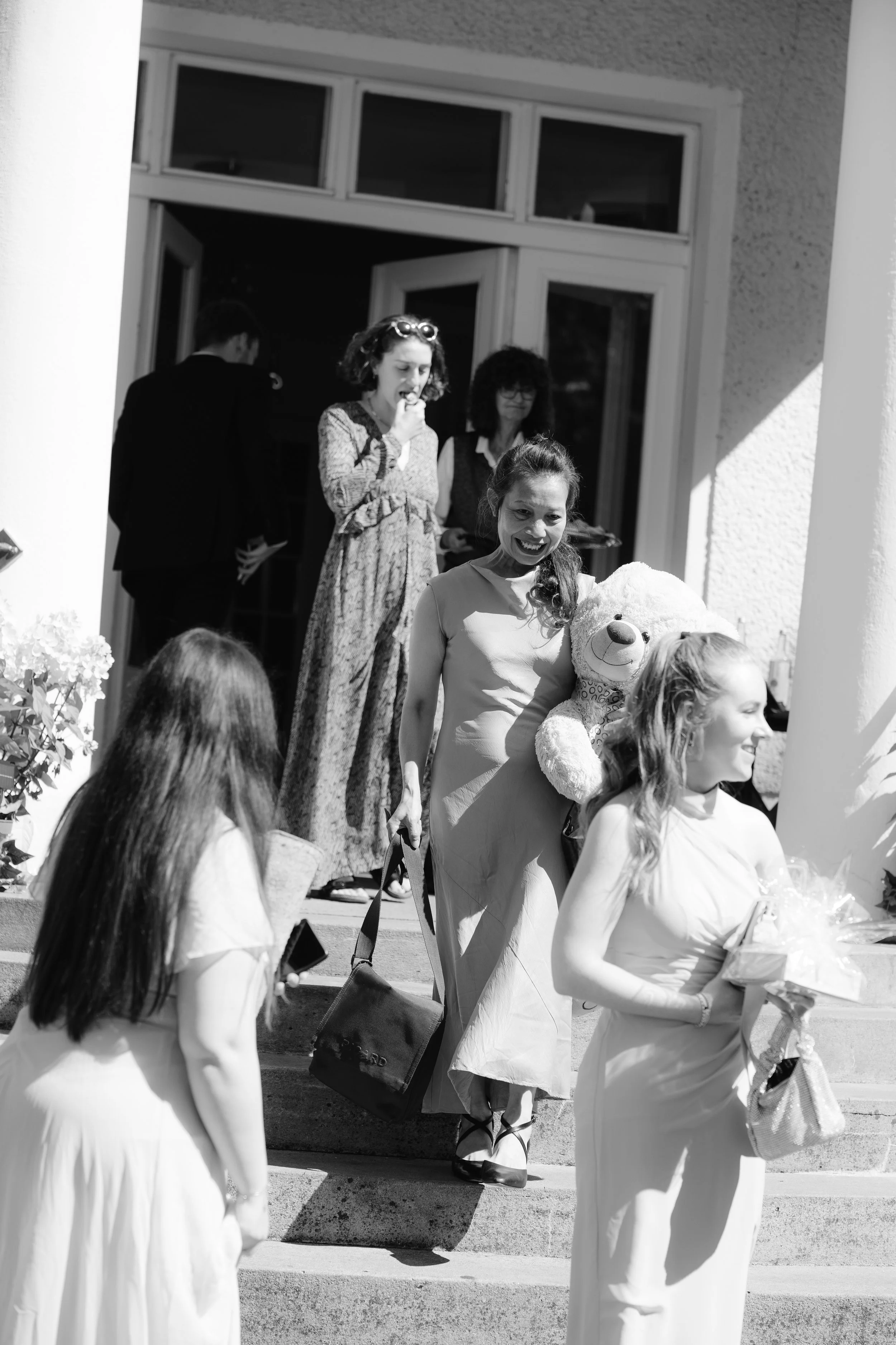 Black and white photo of guests on the steps of a building at Gut Schloss Golm for a reception