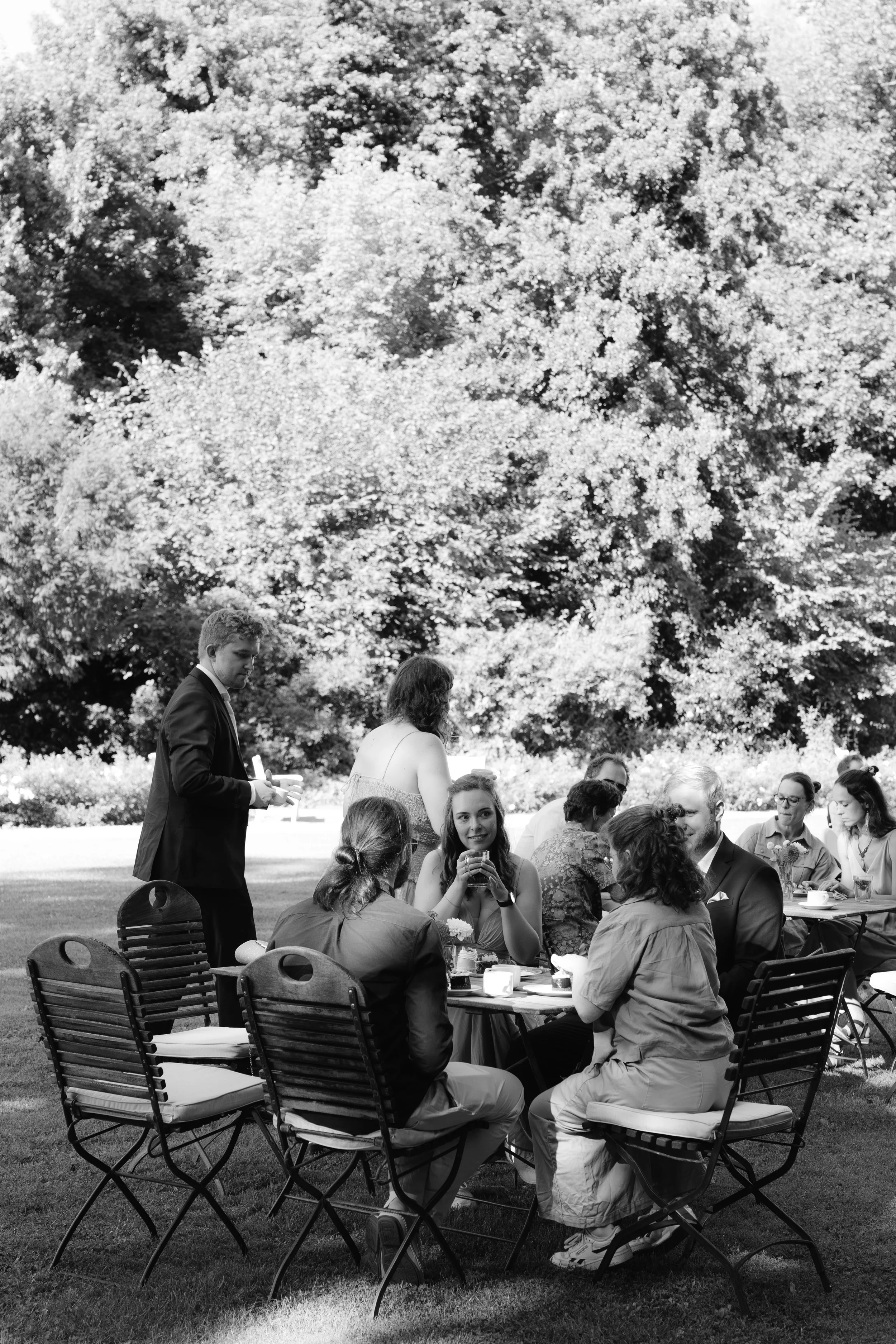 Guests mingling at a reception at Gut Schloss Golm with trees in the background
