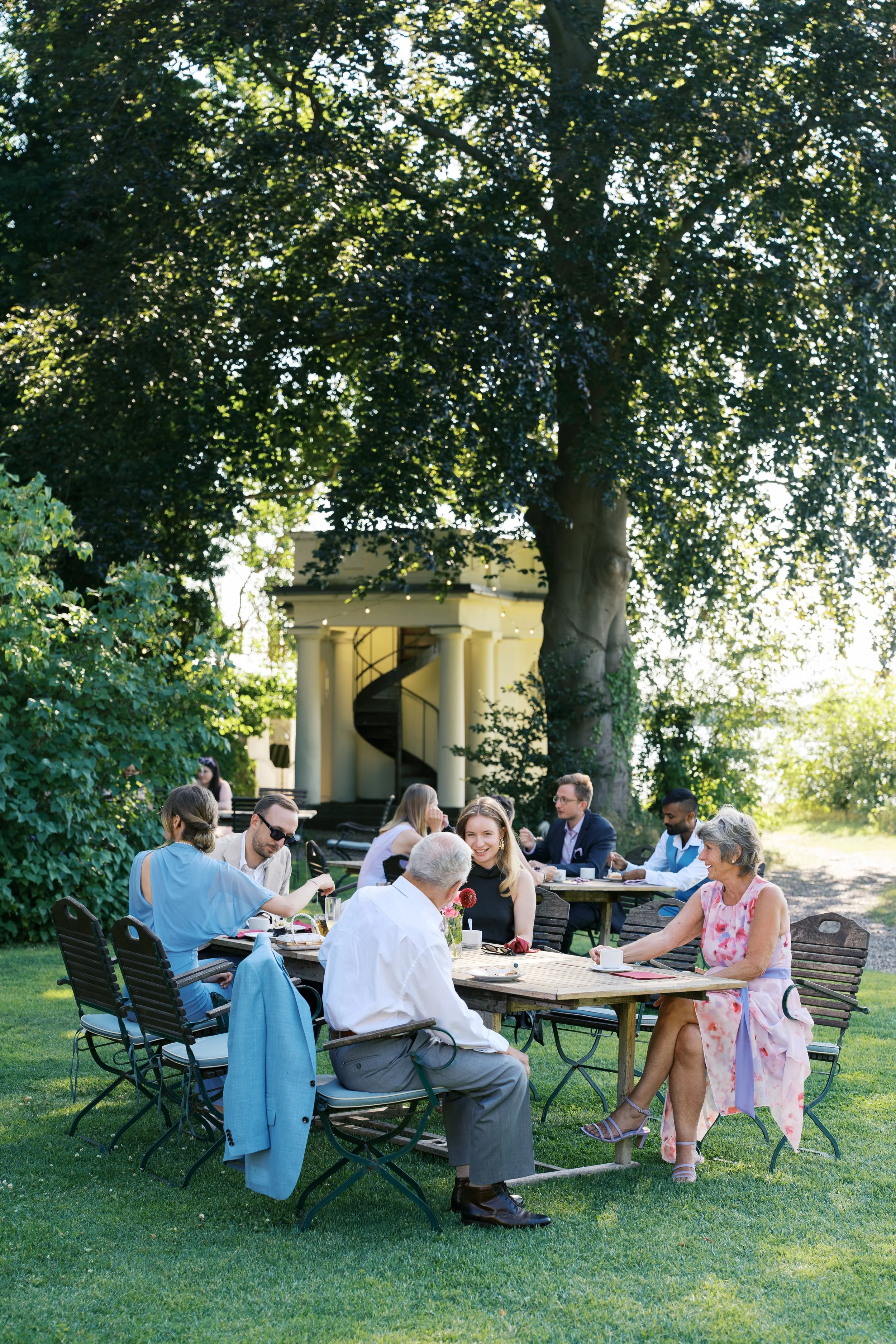 Wedding guests sitting at tables outside at Gut Schloss Golm in Potsdam, Germany