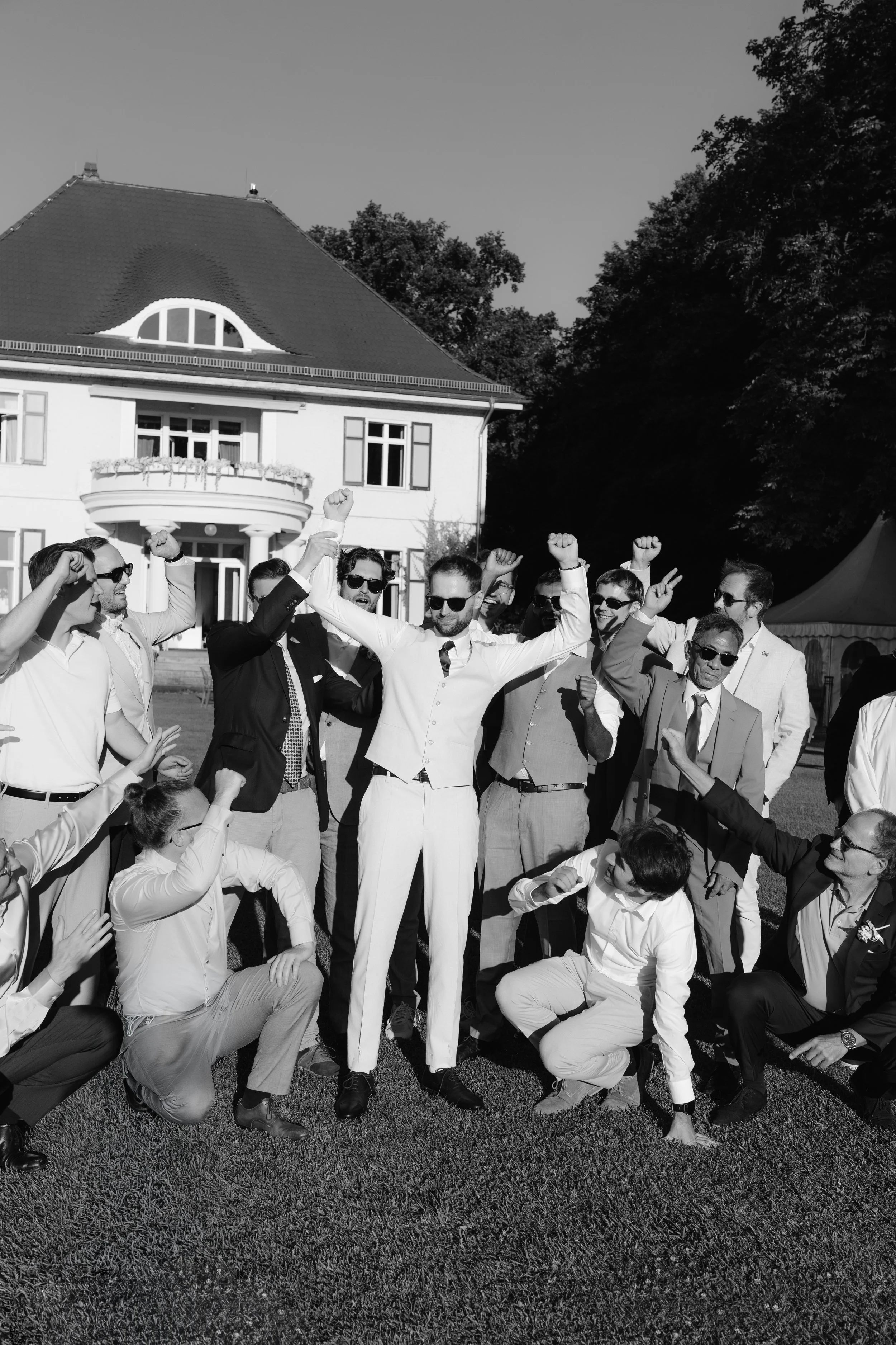 Bride posing with his groomsmen outside of Gut Schloss Golm estate