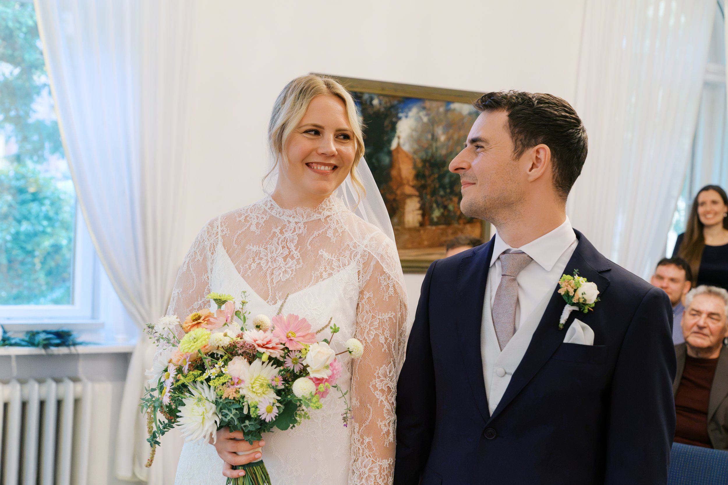 Bride and groom smiling at one another during their ceremony at Hochzeitsvilla
