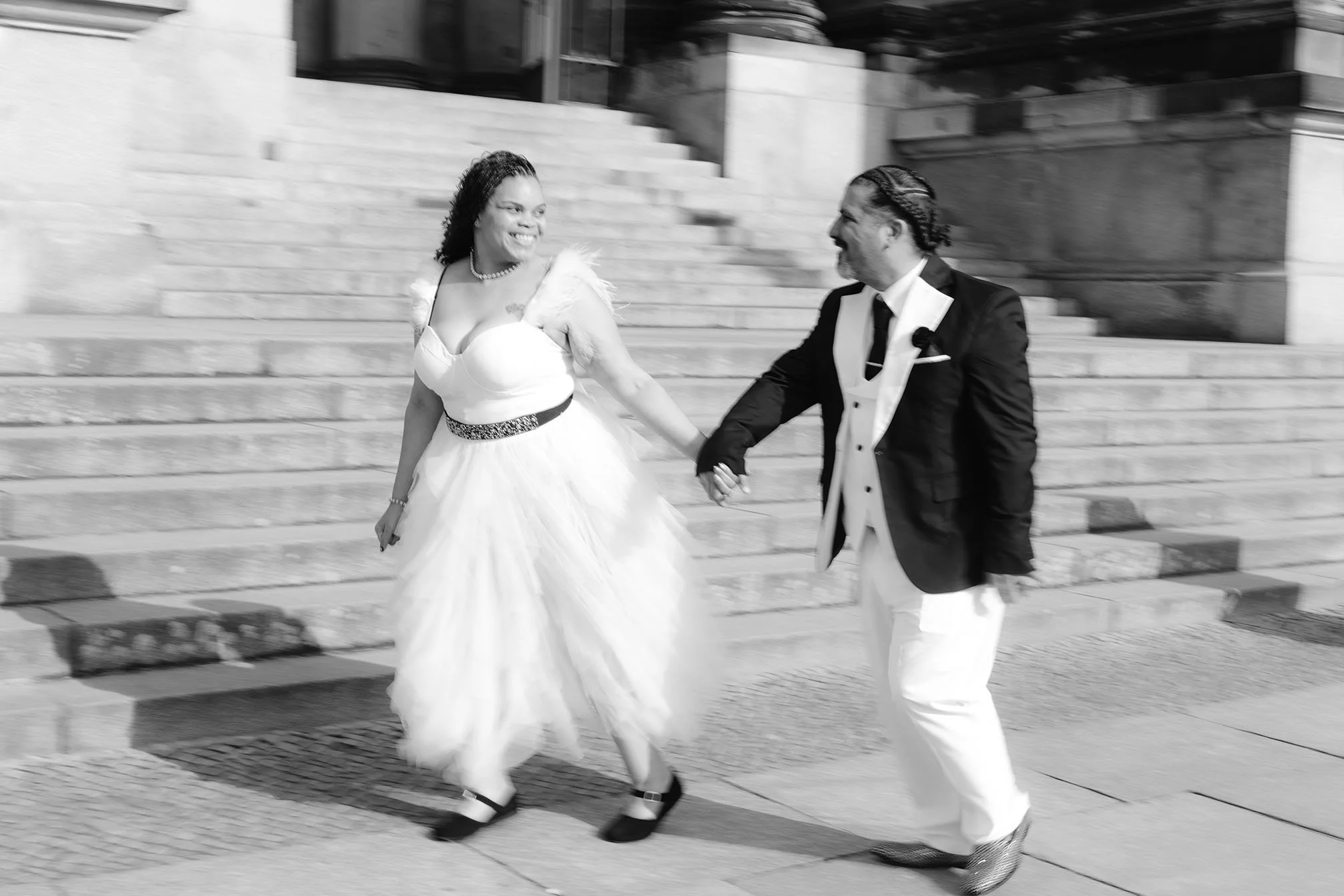 wedding couple holding hands, wearing wedding attire in front of Berlin Cathedral in a Berlin Photoshoot