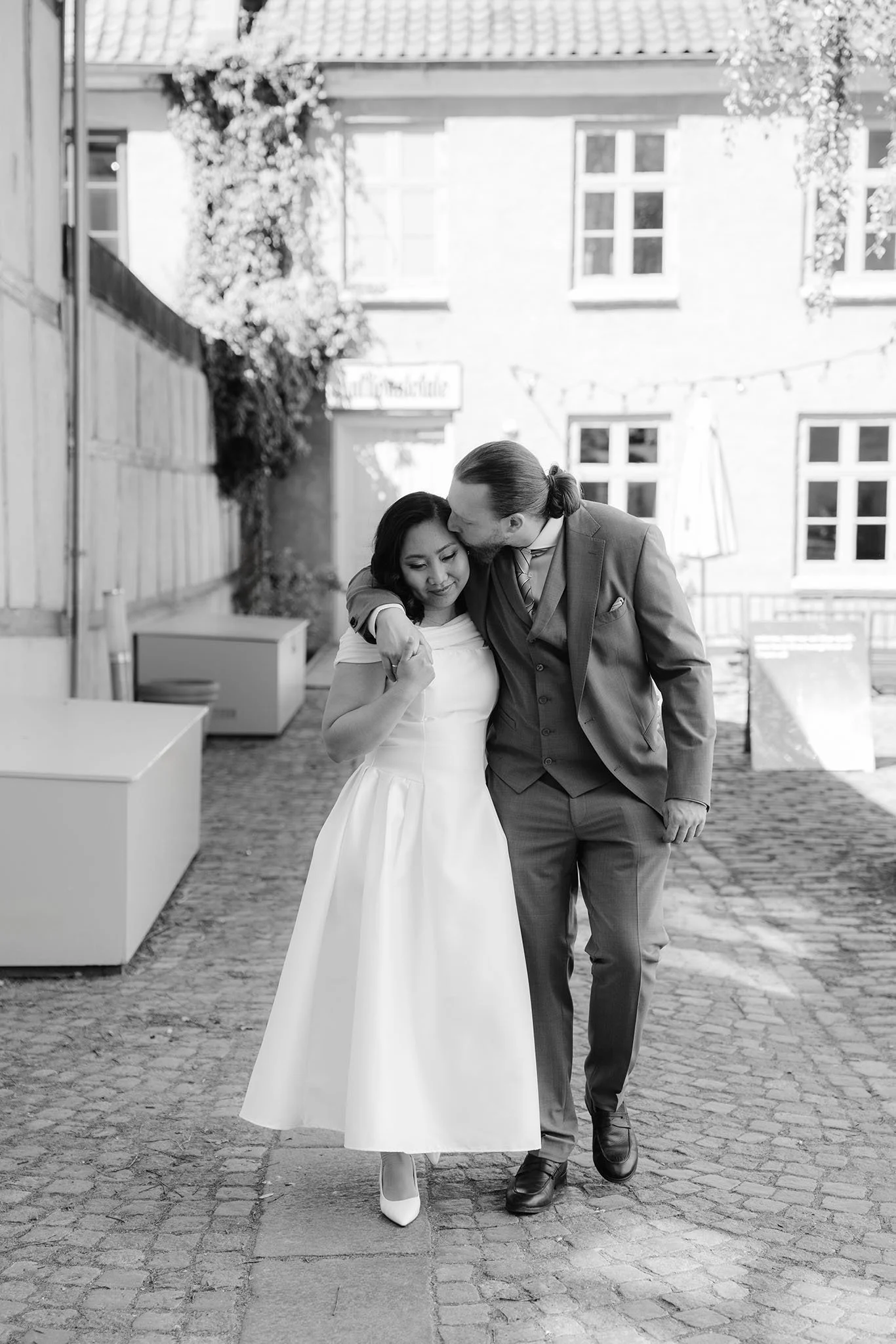 Black and white photos of a romantic wedding couple kissing in the street of Aarhus, Denmark.