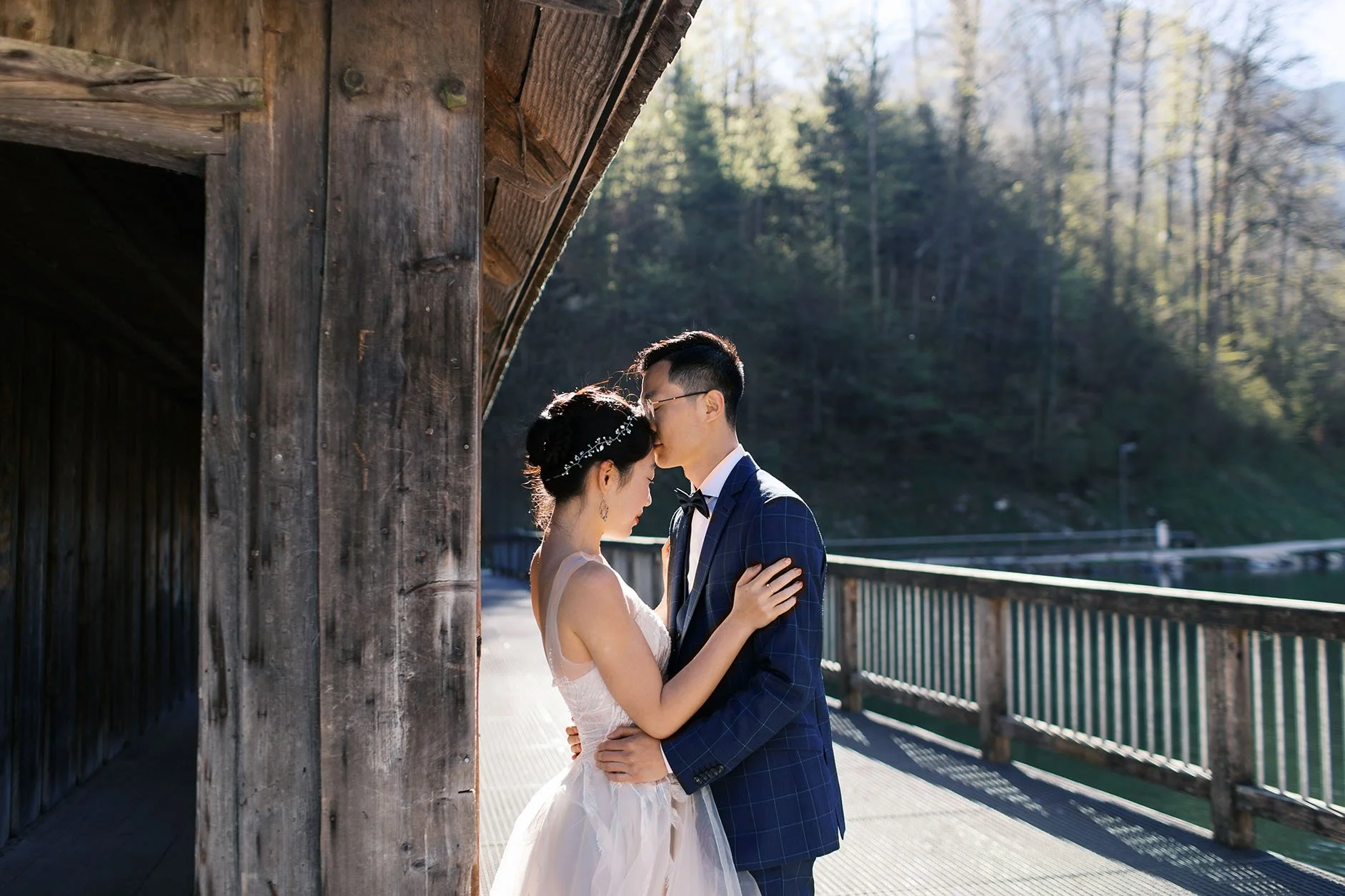An elopement couple hugging each other at a wooden hut by lake Königsee in Germany, captured by Duo Chen Photography