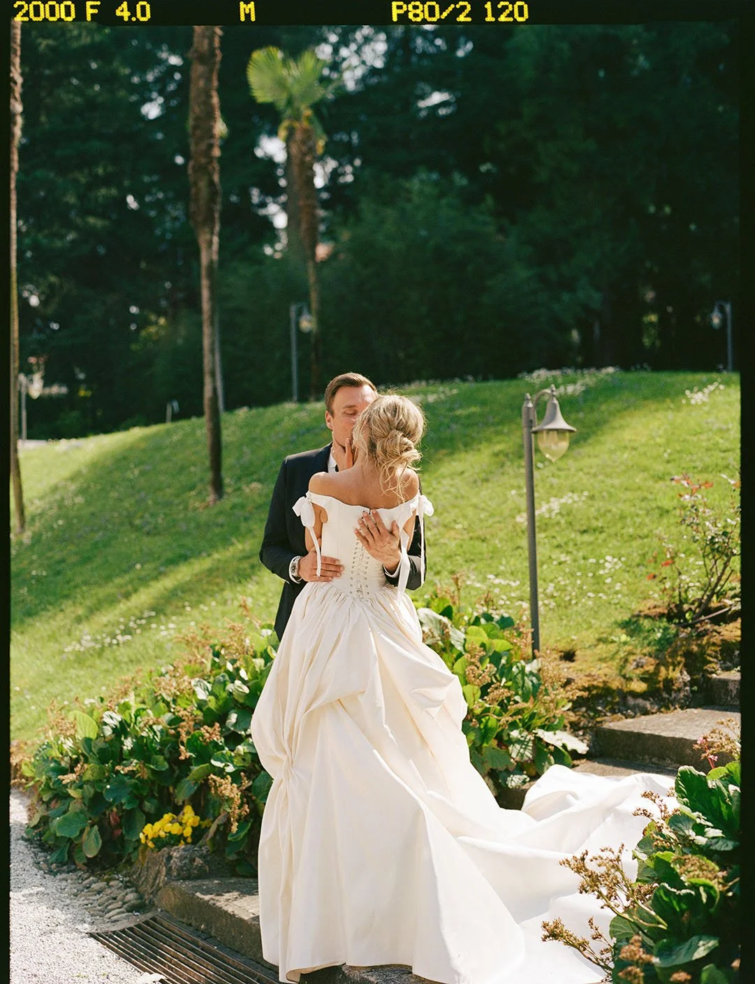 A wedding couple kissing at a garden in front of a villa at Lake Como by Berlin wedding photographer Duo Chen