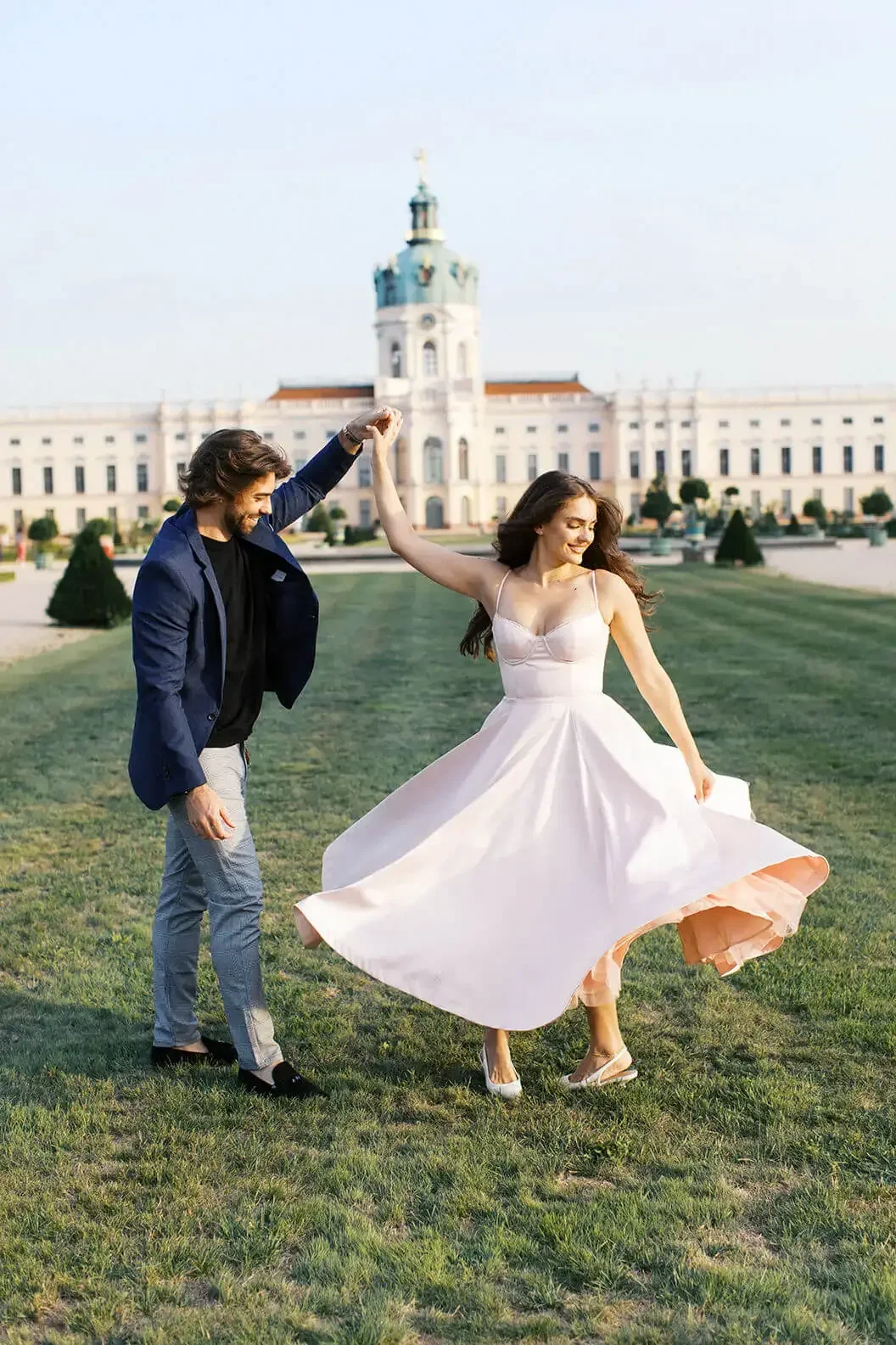a dancing engaged couple in front of Schloss Charlottenburg in Berlin by Duo Chen