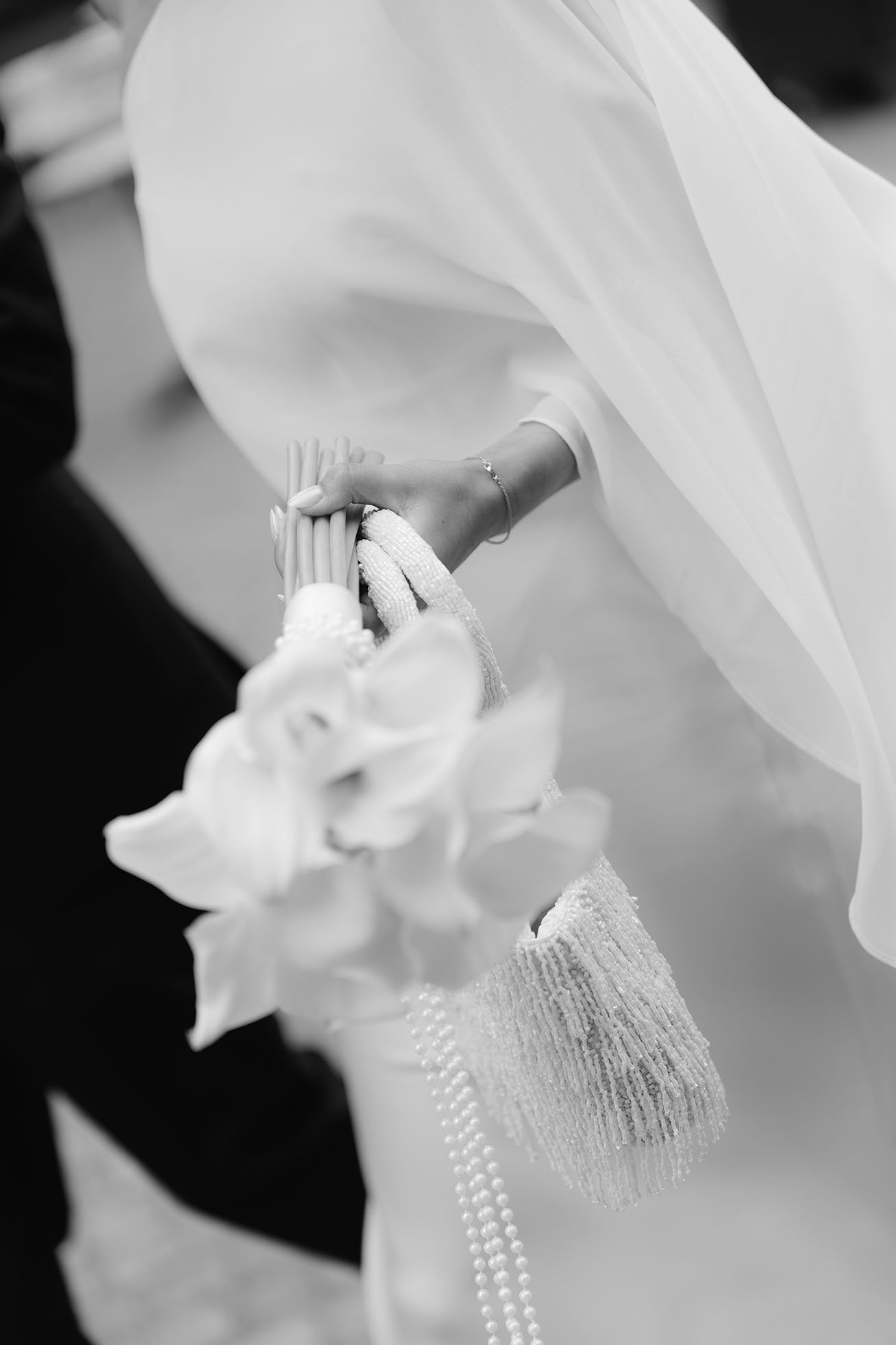 Close up of a bride holding the wedding bouquet and a matching purse.