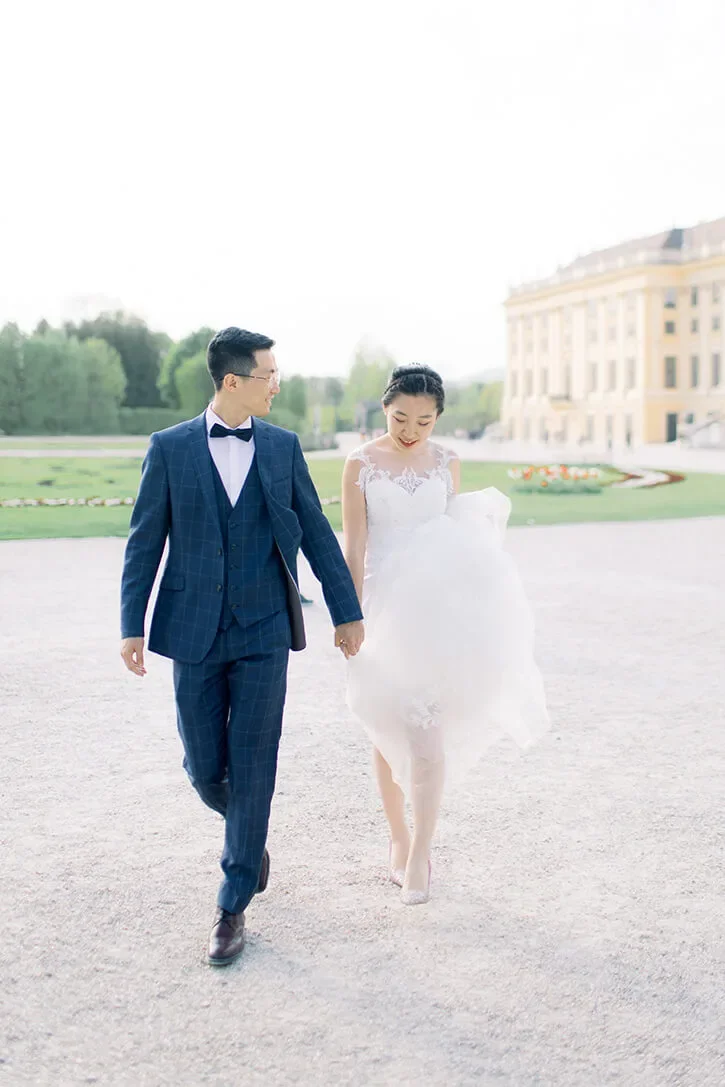 A asian couple holding hands and walking in a garden, captured by Duo Chen Photography