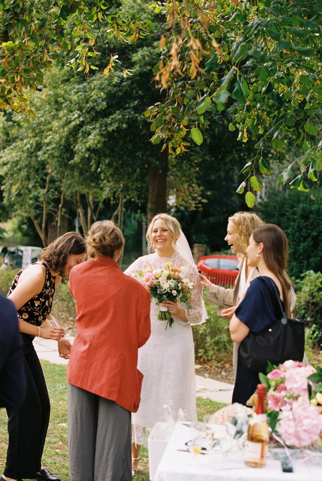 Candid group photo of a bride laughing with her guests in Standesamt Zehlendorf, Berlin