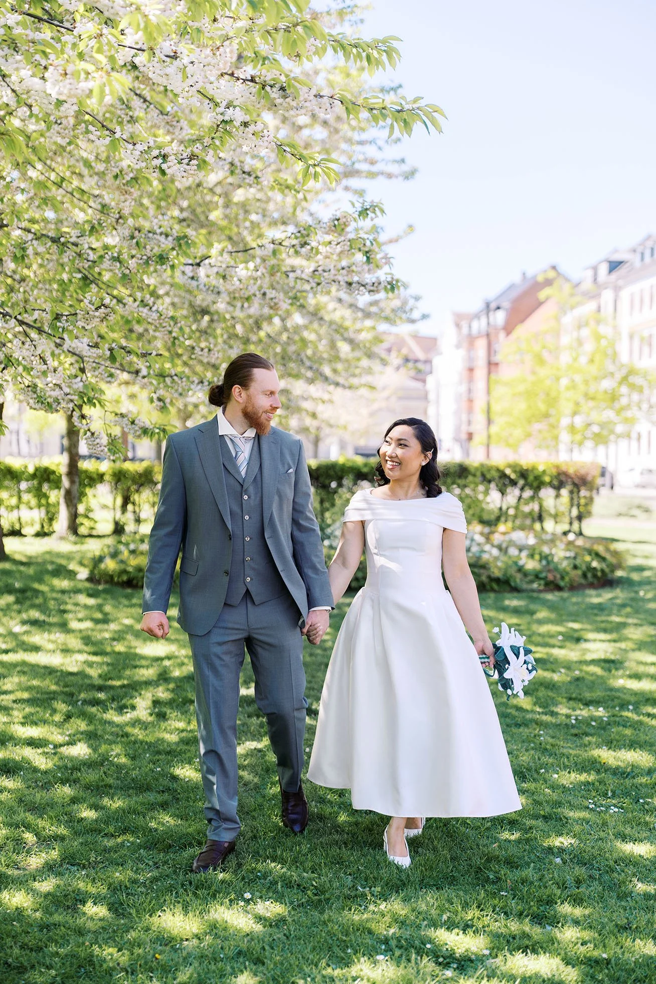 Portrait of a wedding couple in the garden with trees on a sunny day.