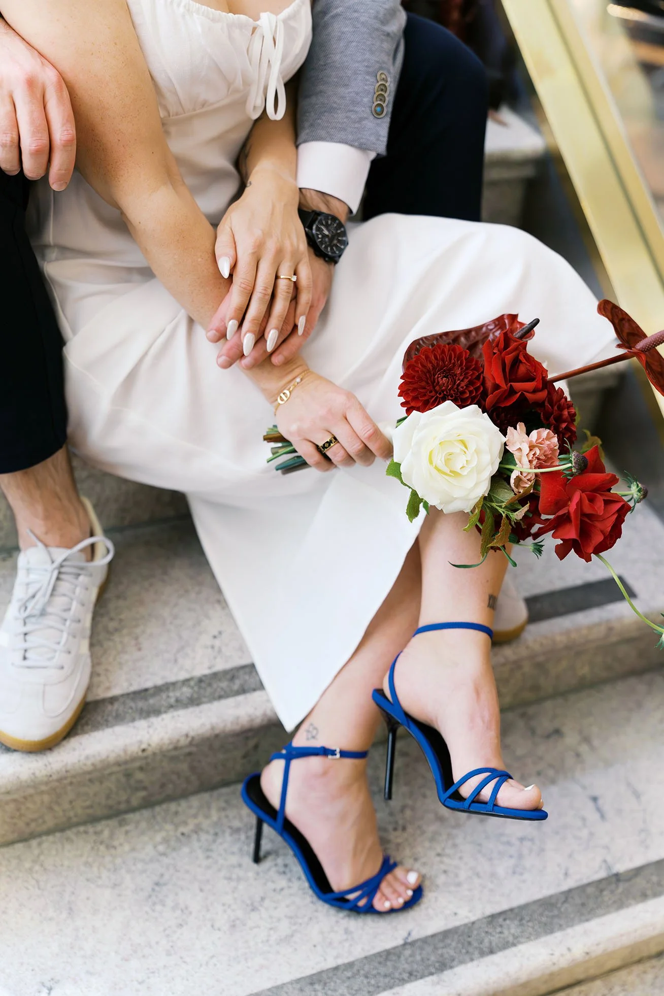 A close-up of a couplee sitting on steps, celebrating their engagement in Berlin, shot by Duo Chen Photography.