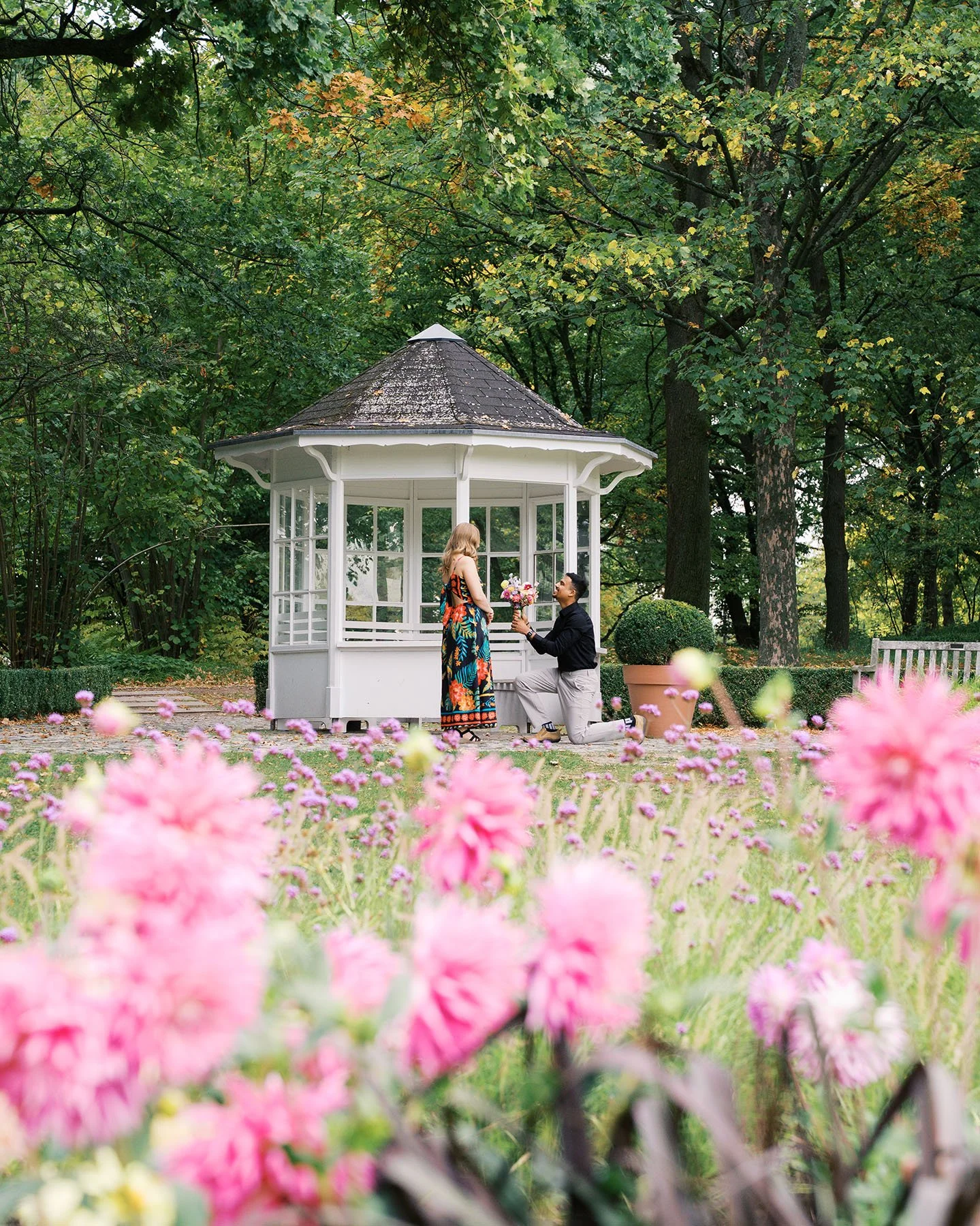 A guy is proposing to his girlfriend with a bouquet in his hand in Britzer Garten, Berlin.