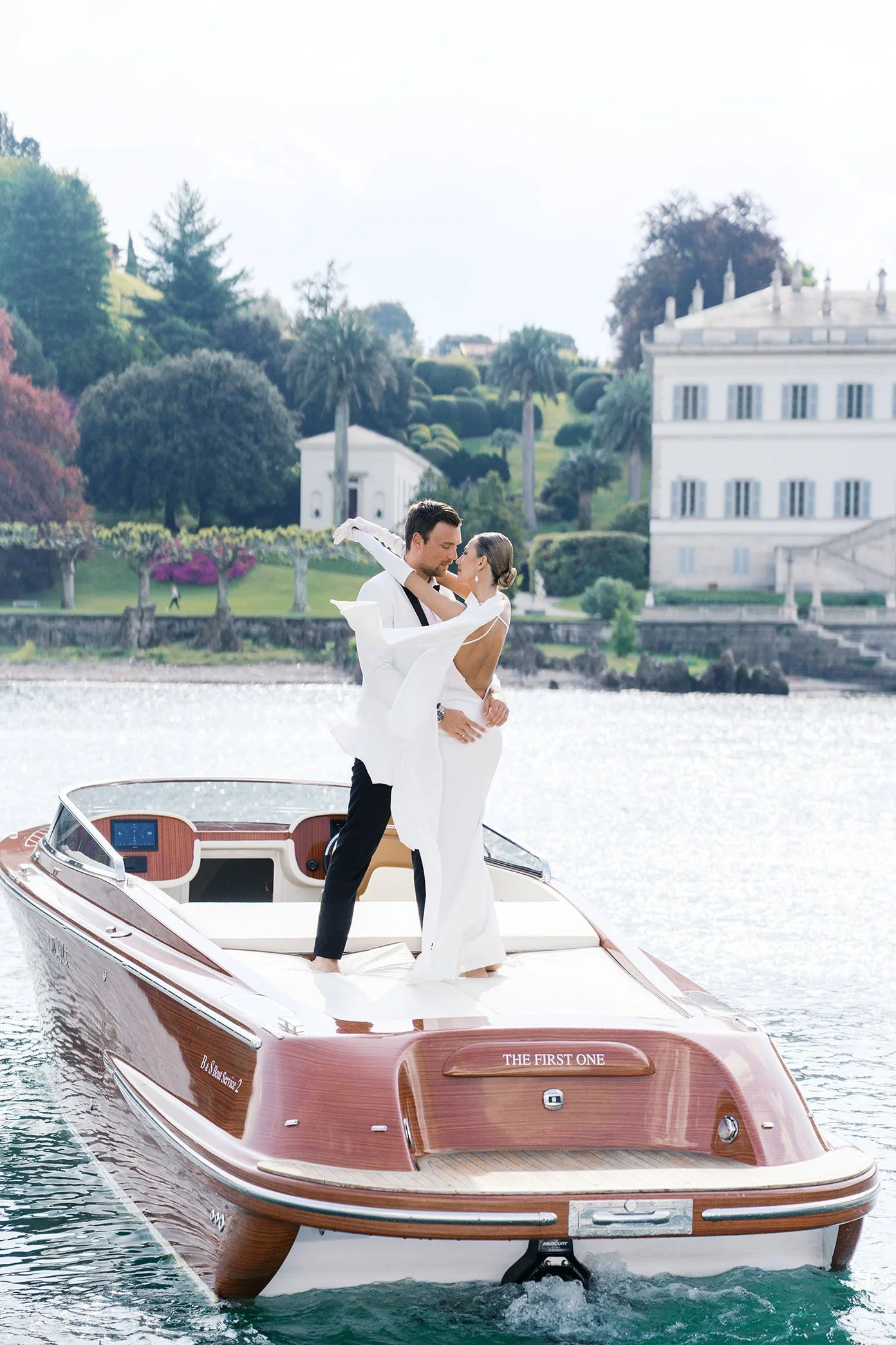 A wedding couple posing on a boat ride at Lake Como in Italy, by Duo Chen.