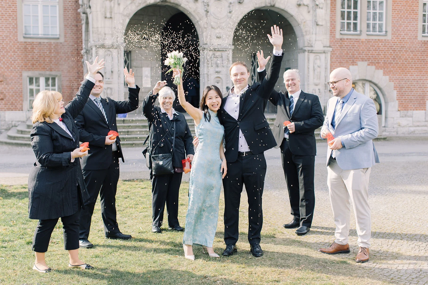 A festive send off with rice toss after a couple's civil wedding in front of Standesamt Reinickendorf by Duo Chen Photography
